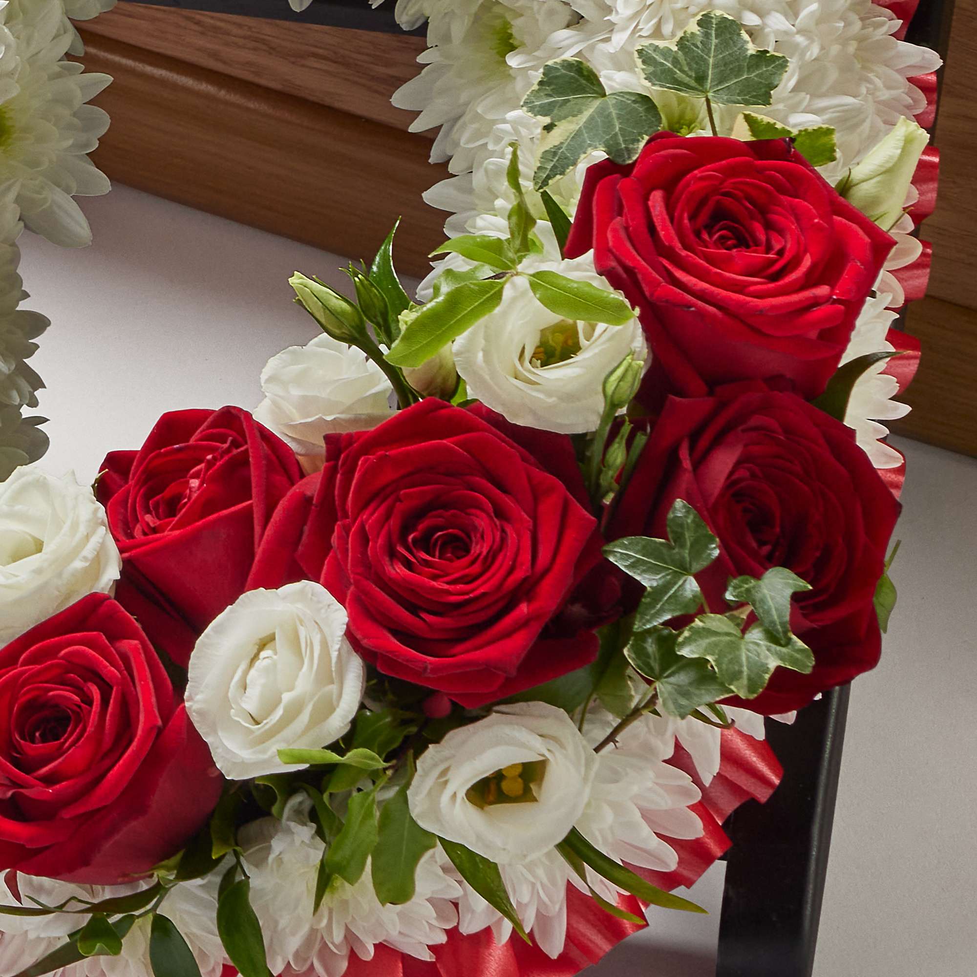 Zoomed in shot of red and white flowers spelling out the word 'Dad'