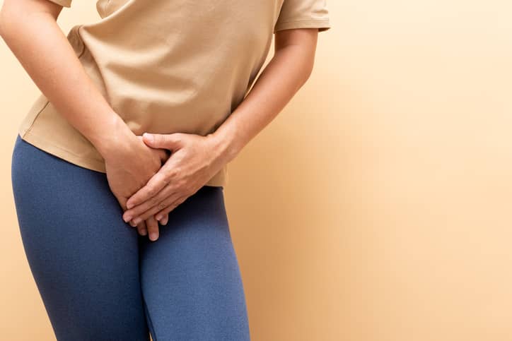 Woman holding her crotch due to frequent urination