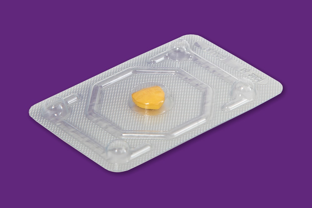 Yellow emergency contraception pill plan b in silver packet on purple background