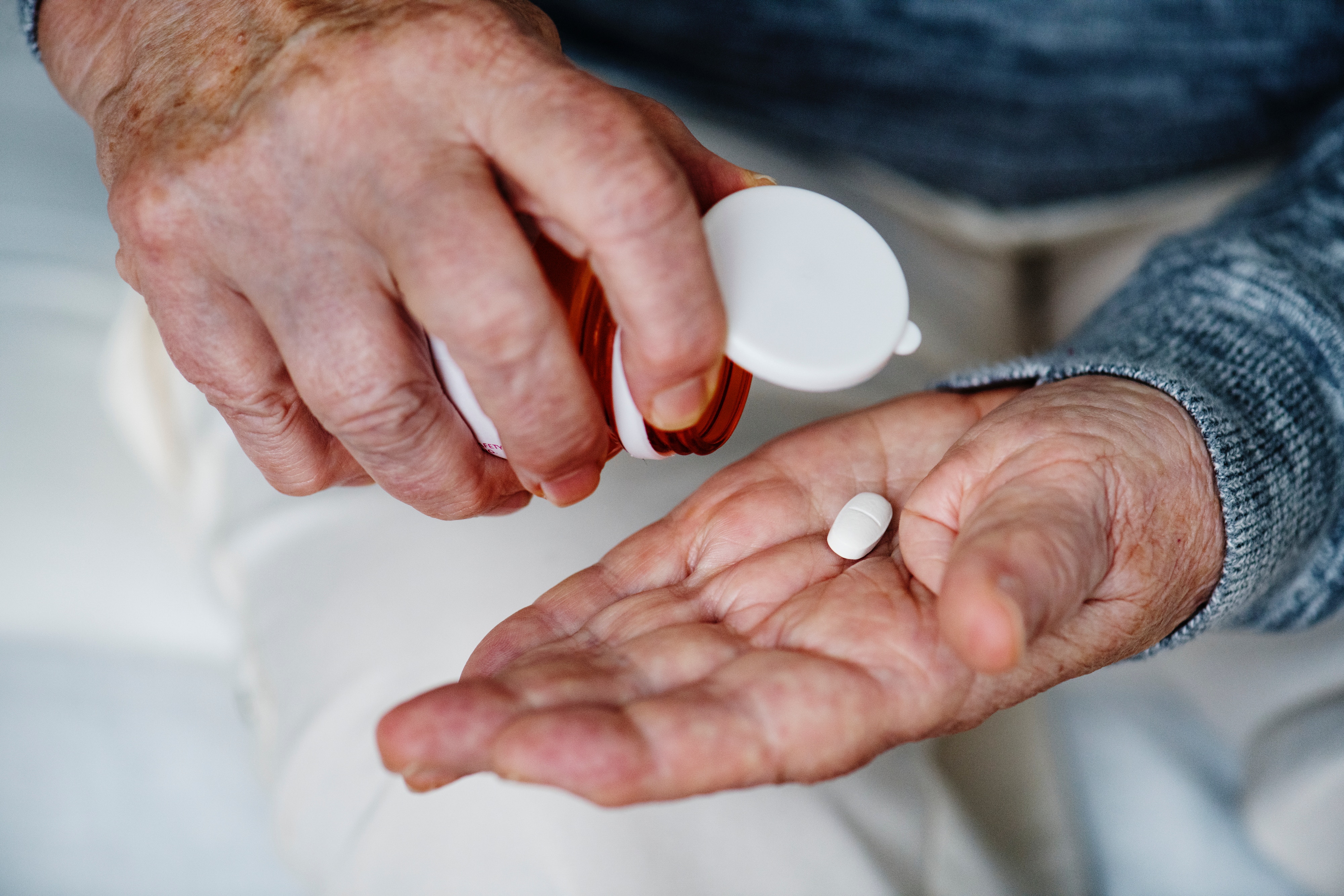 A person tipping a pill out of a bottle