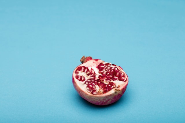 Half a pomegranate on blue background