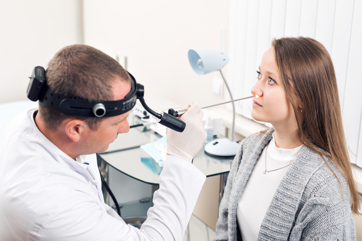 Doctor with patient looking at her nose 