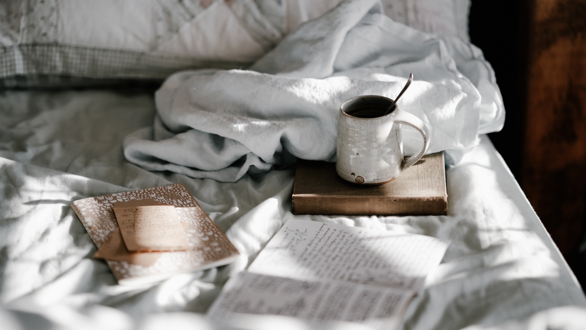 Journal and mug on a bed