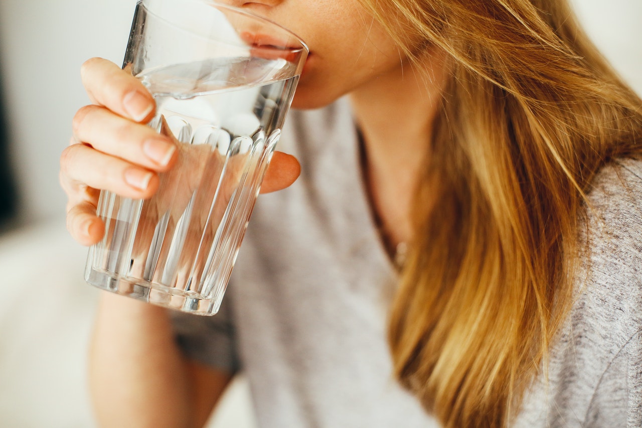 Close-up of young woman sipping from a glass of water (Credit - Daria Shevtsova)