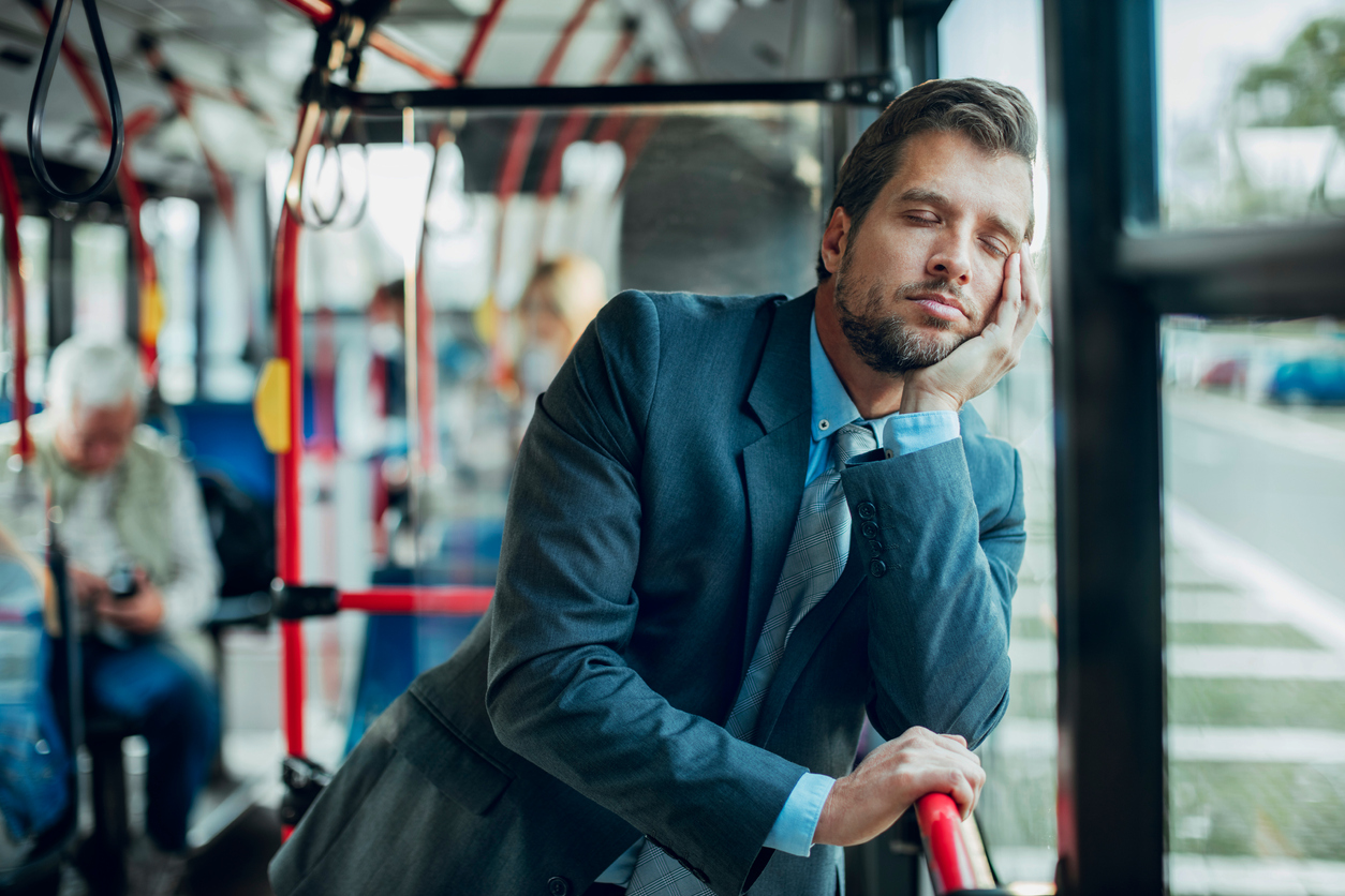 Tired businessman riding in bus on commute