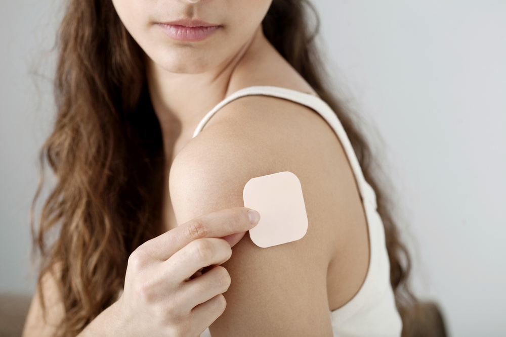 Woman with contraceptive patch on arm