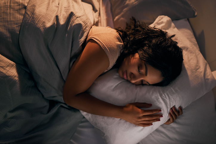 Young woman sleeping in her bed at home during the night