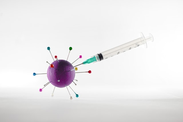 Syringe injecting COVID-19 cell with a vaccine