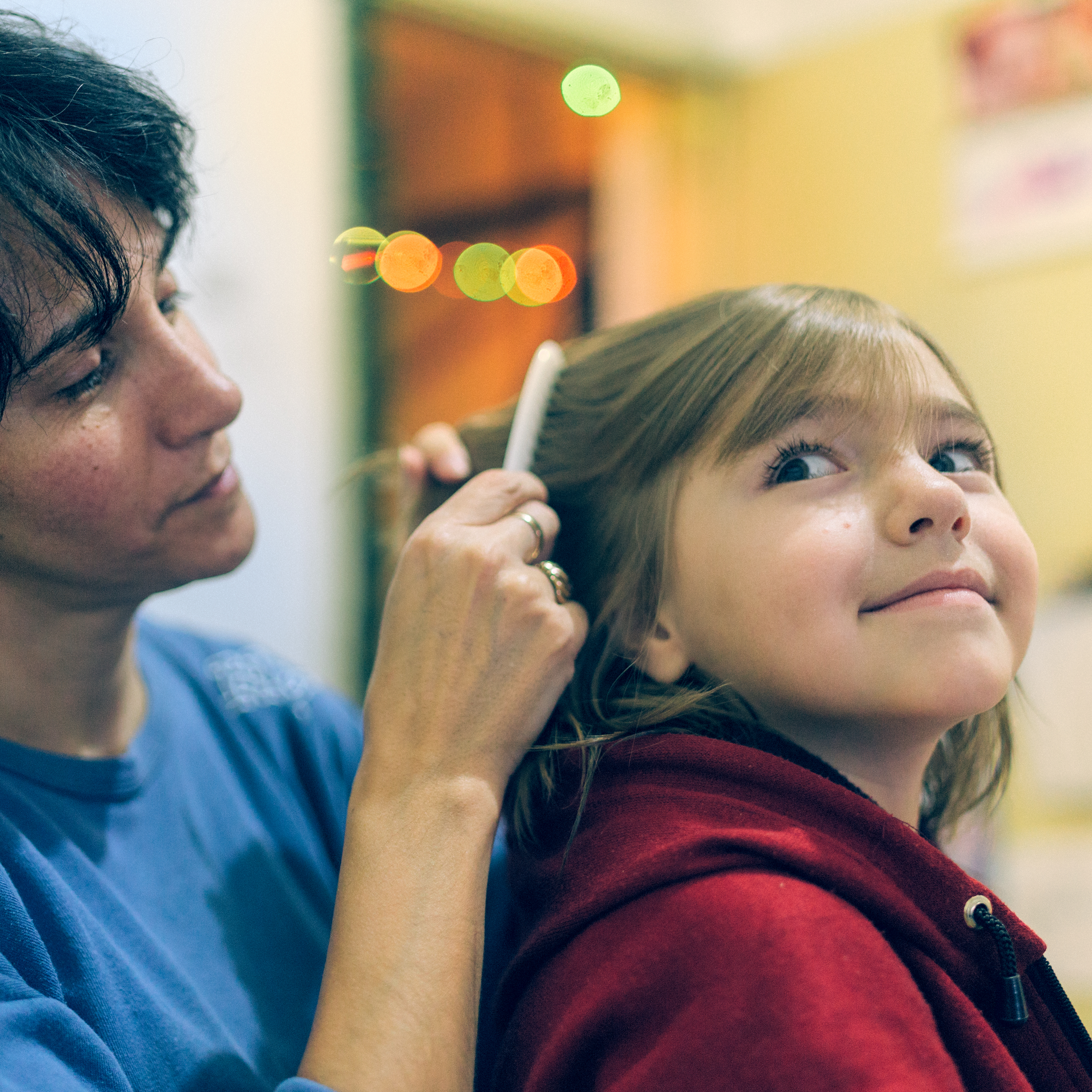 Mother using a comb to look for head