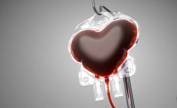 Heart shaped blood bag for a blood transfusion on a grey background