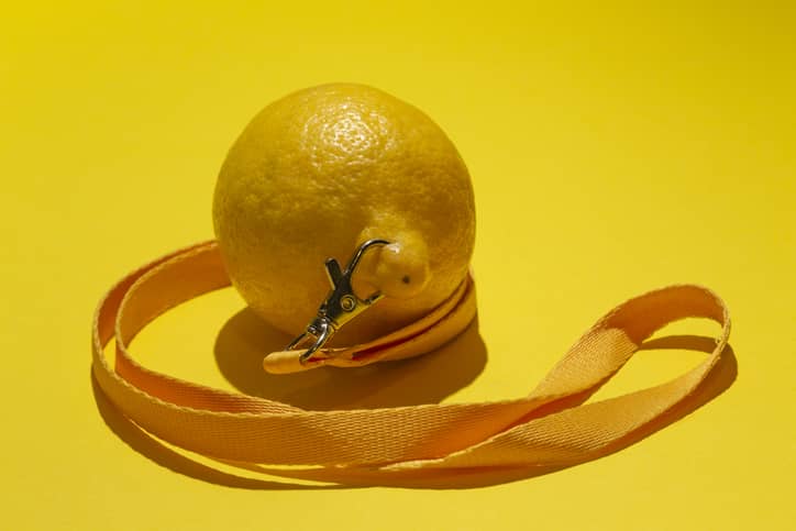 Conceptual photograph of a lemon with a piercing on a yellow background