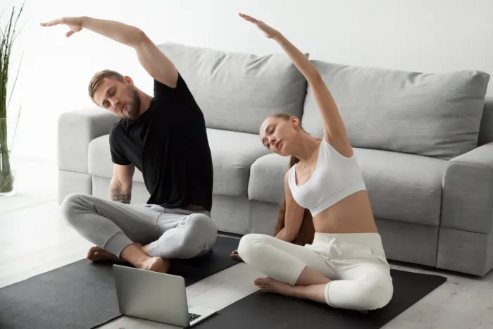 Young couple doing yoga in living room
