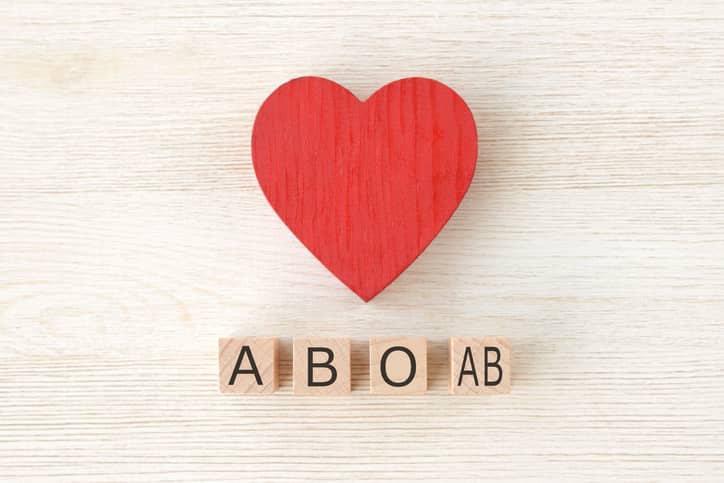 Red wooden heart above four wooden blocks with the letters A, B, O and AB