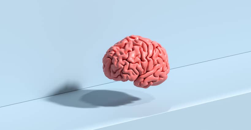 Pink floating brain model on a blue background