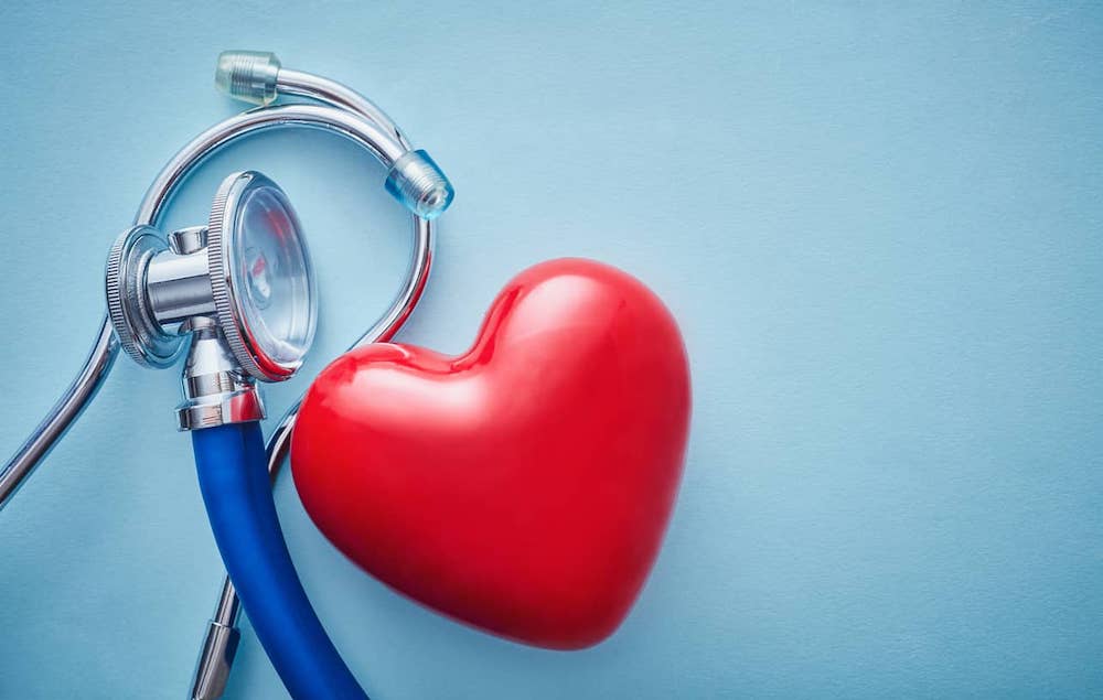 Red heart and stethoscope on blue background for cardiovascular disease awareness