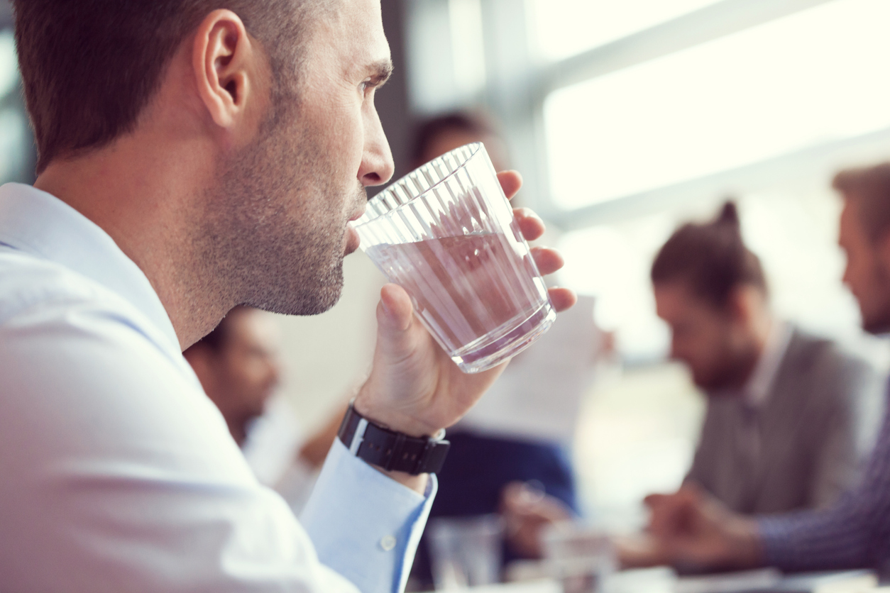 Man drinking water at a meeting
