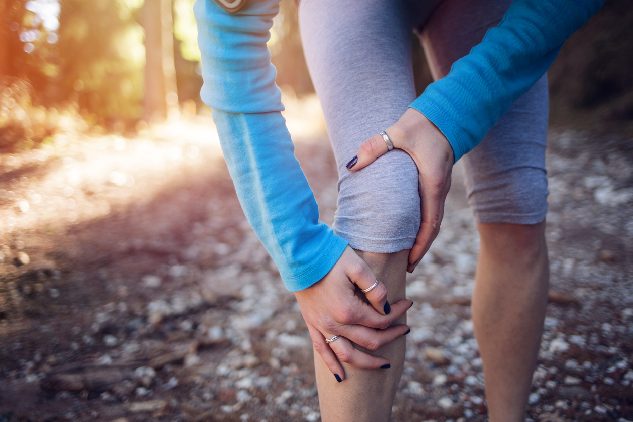 Woman holding her knee knee injury