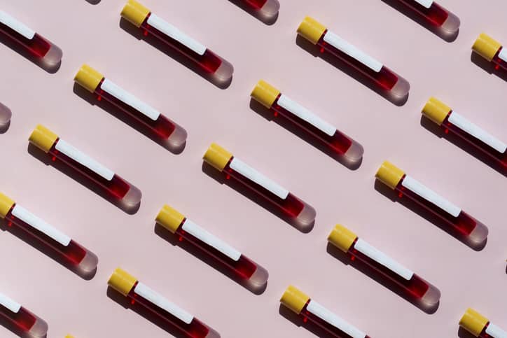 Rows of blood test tubes on a pink background