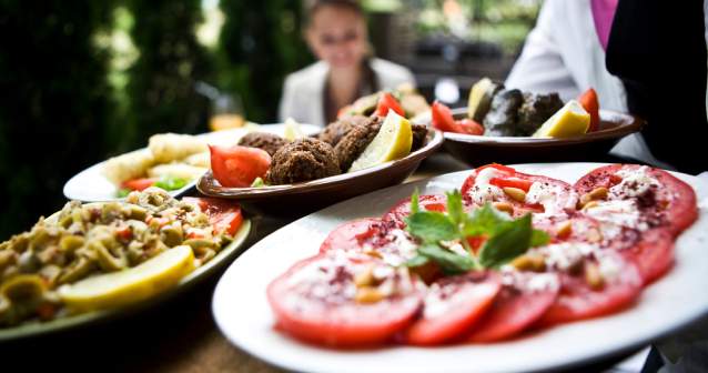 Waiter holding plates of foods that are part of a mediterranean diet which could help ease hay fever symptoms