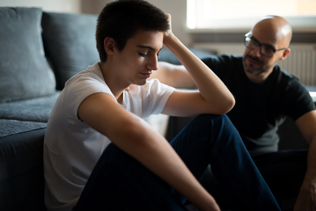 Dad talking to son by sofa