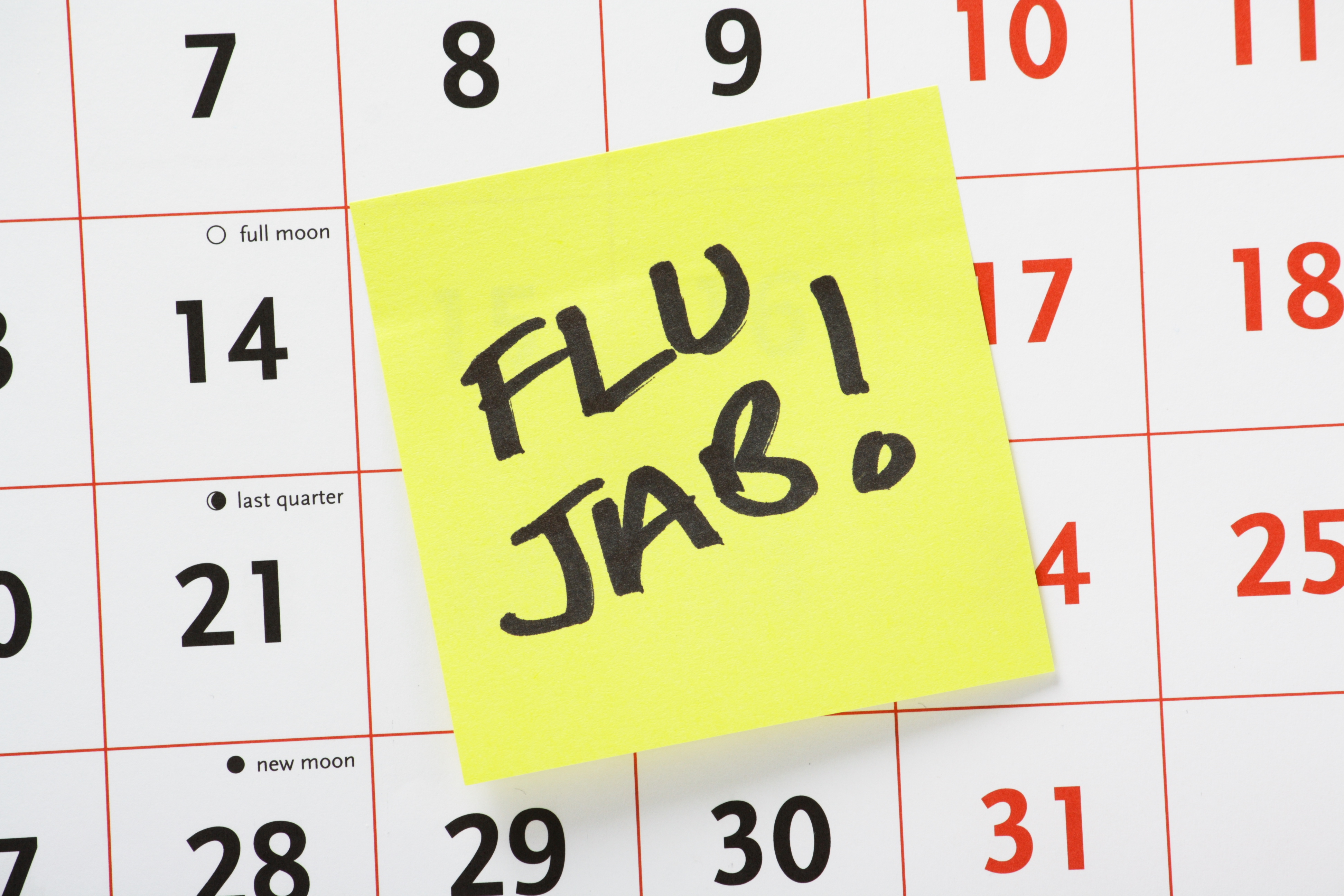 Post-it note that says flu jab on a calender