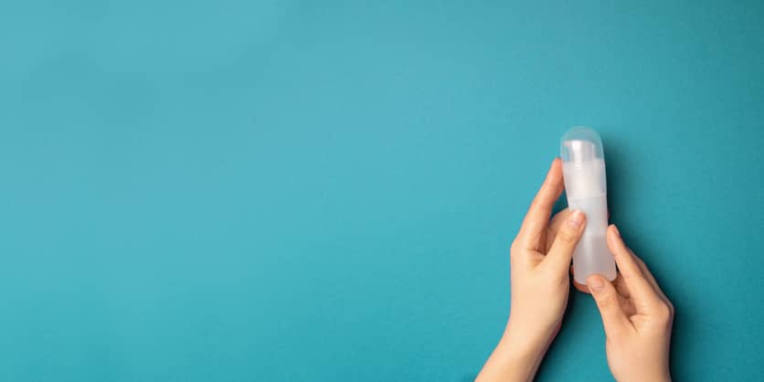 Person Holding A Clear Pump Dispenser Of Lubricant For Sex