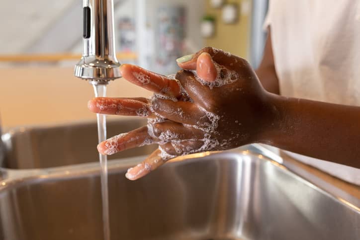 Washing hands in sink to prevent food poisoning
