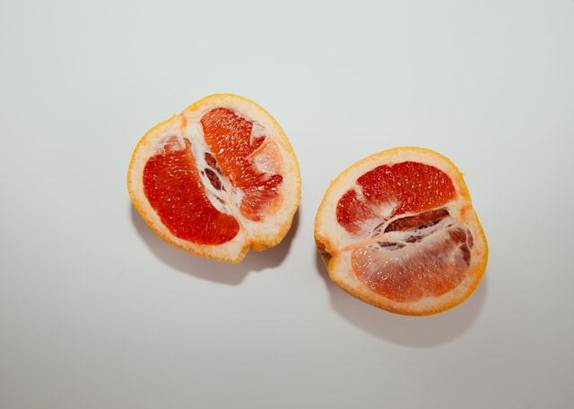 Two orange halves on a grey background