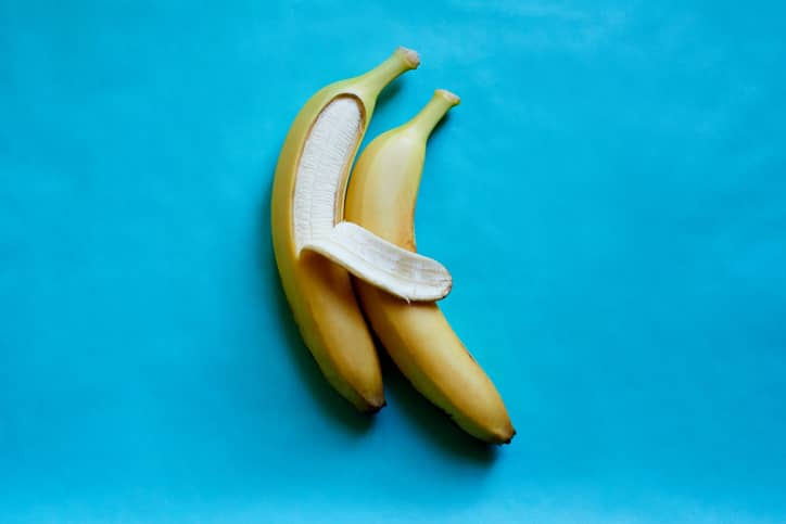 2 bananas lying side by side against a blue background