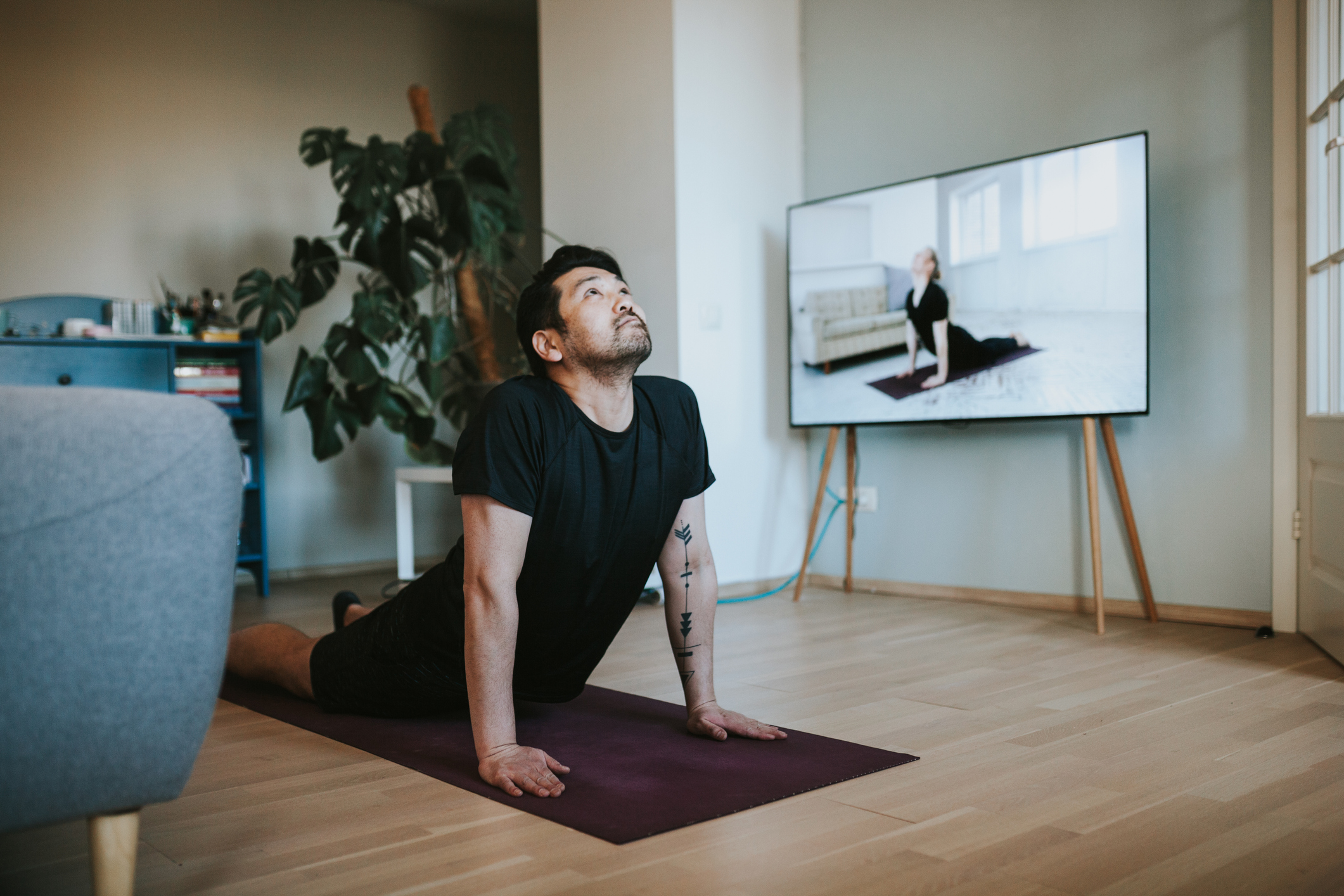 Man taking online yoga lessons during lockdown in isolation