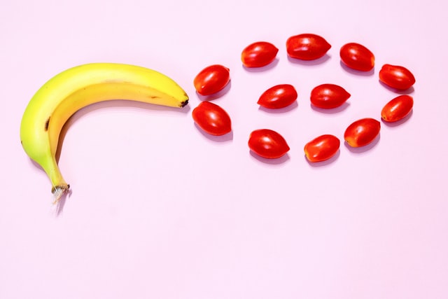 Banana pointing at circle of cherry tomatoes