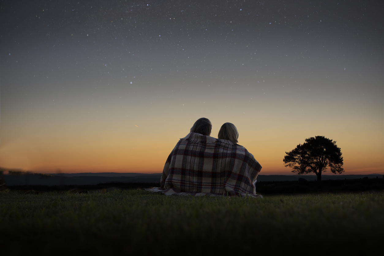 2 people sat on the grass at night