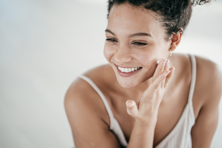 Young women applying moisturiser to her face
