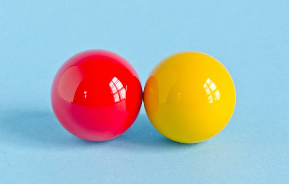 Red and yellow pool billiard balls to show testicles testicular cancer
