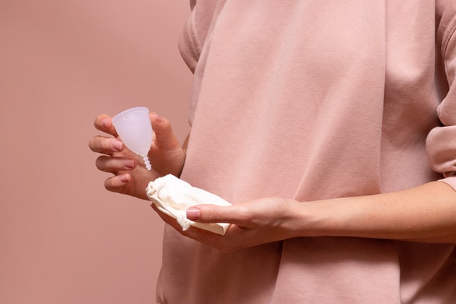 Person holding bag and clean menstrual cup