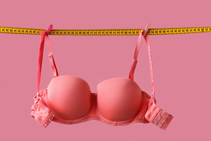 Pink bra on a tape measuring breast size