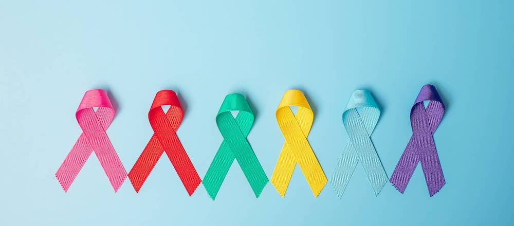 Colourful cancer awareness ribbons on blue background