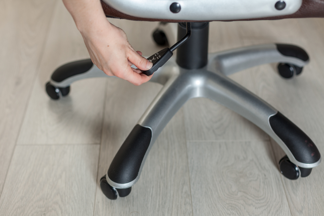 Close up of someone adjusting the height of an office chair