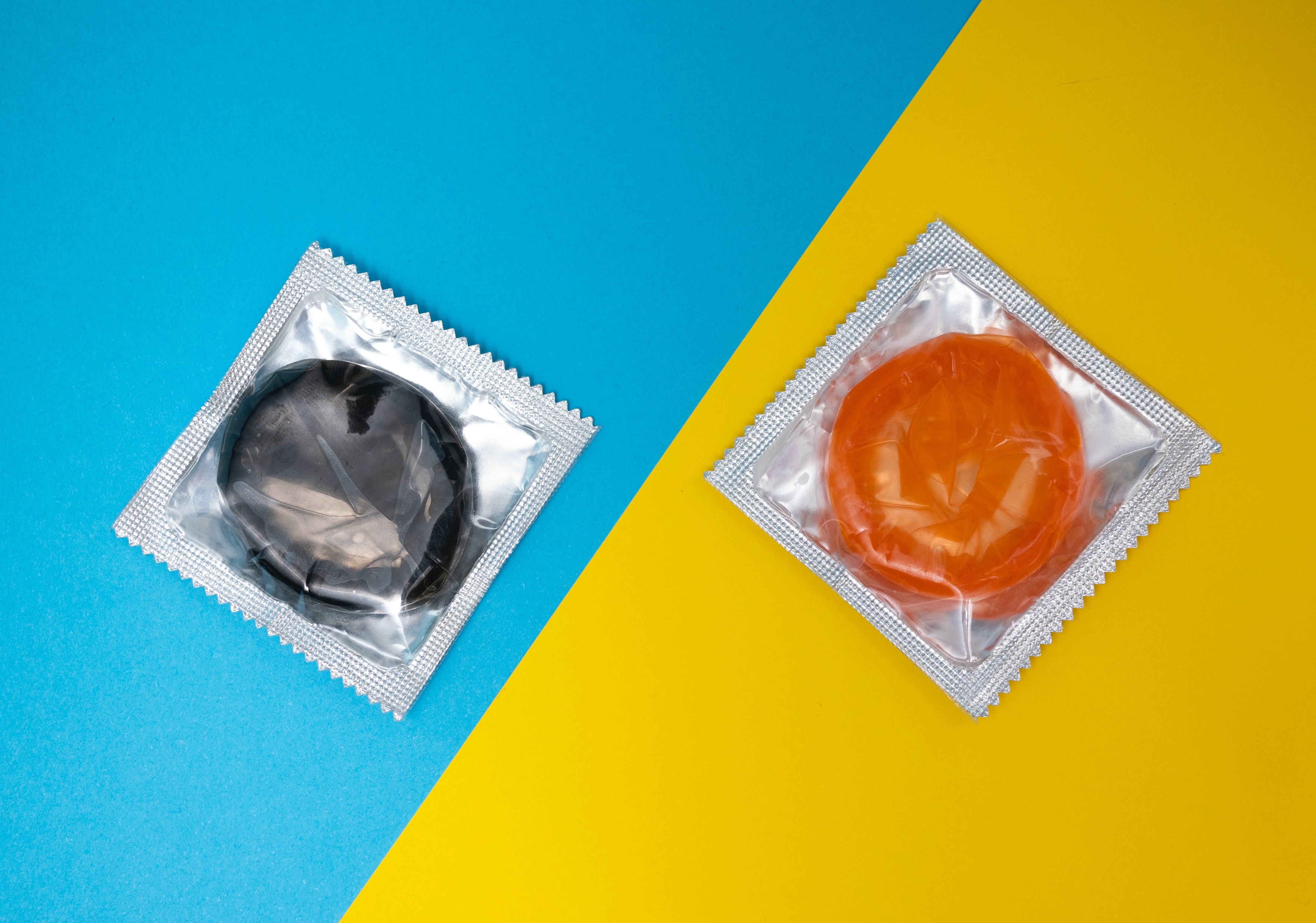 Two condoms on a blue-yellow background- Photo by Reproductive Health Supplies Coalition on Unsplash