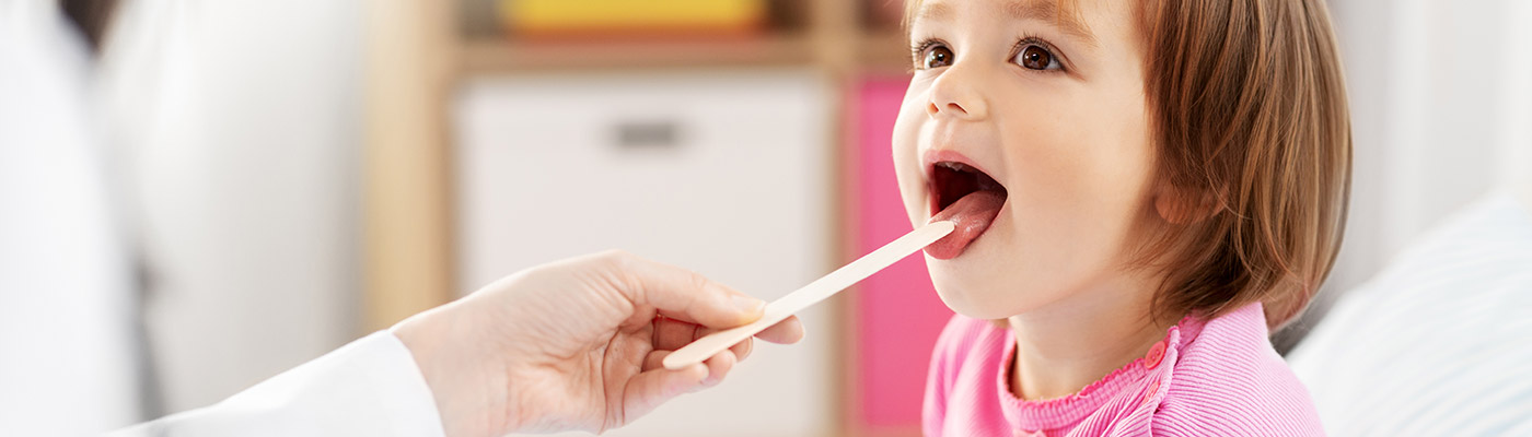 DOCTORA REVISANDO LA GARGANTA DE NIÑA