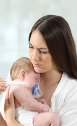 MAMÁ CARGANDO BEBÉ CON FIEBRE