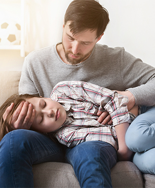 PAPÁ CUIDANDO A HIJO CON DOLOR DE CABEZA