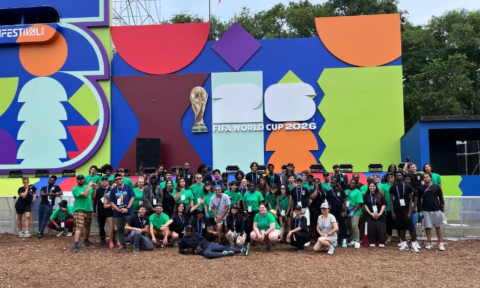 FIFA workers together in front of a large FIFA World Cup 2026 sign