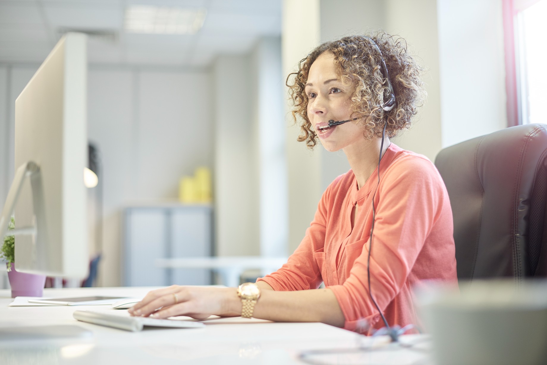 a call center agent sitting at her desk on a headset