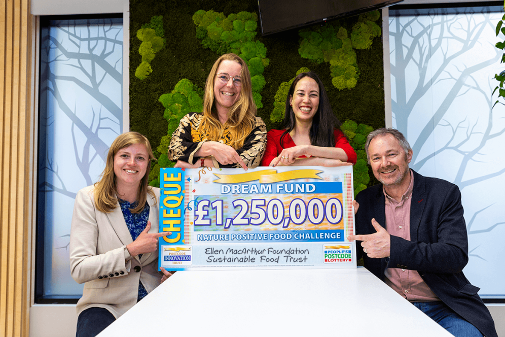 Photo of 4 people holding a cheque