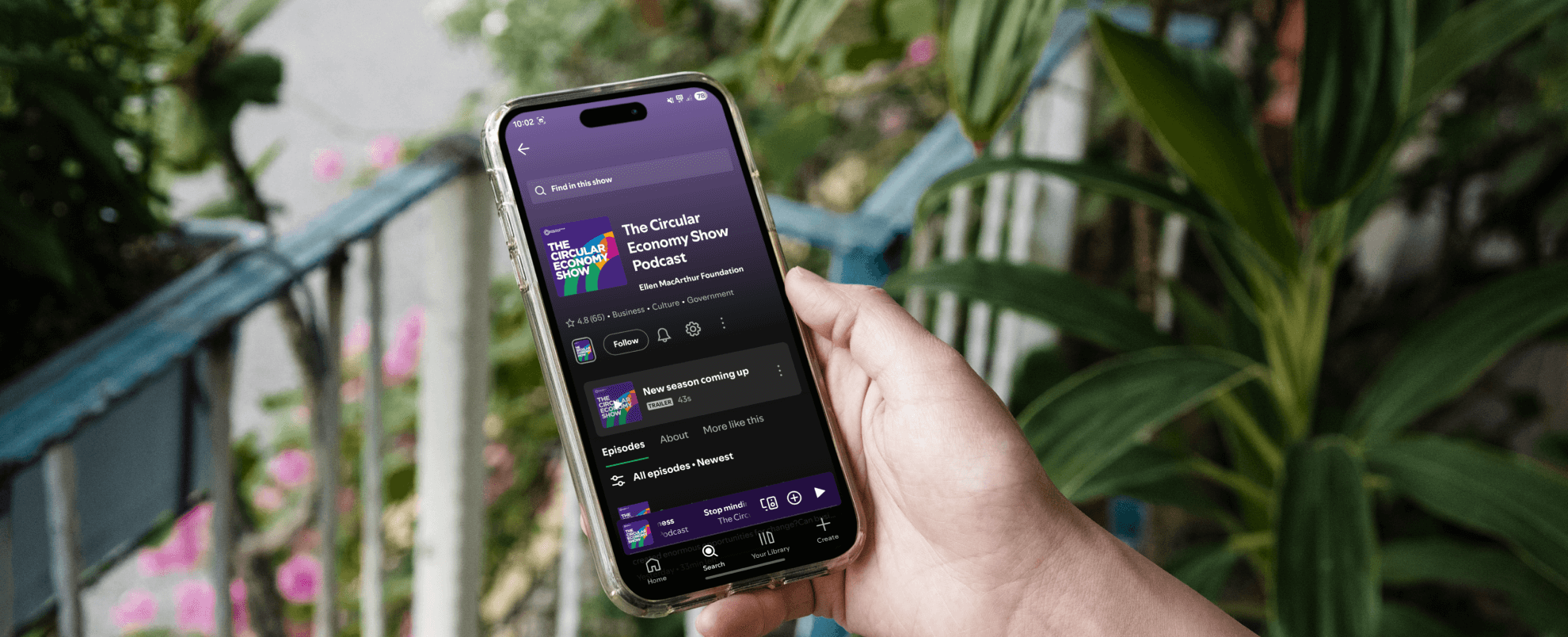 Person holding a phone that is displaying the podcast channel