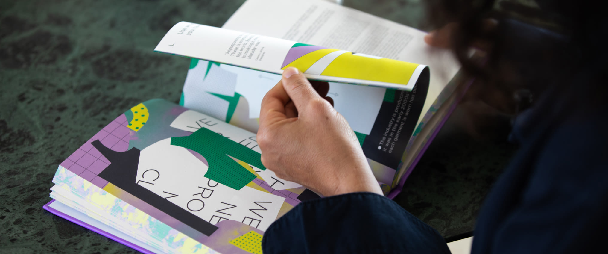 Person reading circular design for fashion book
