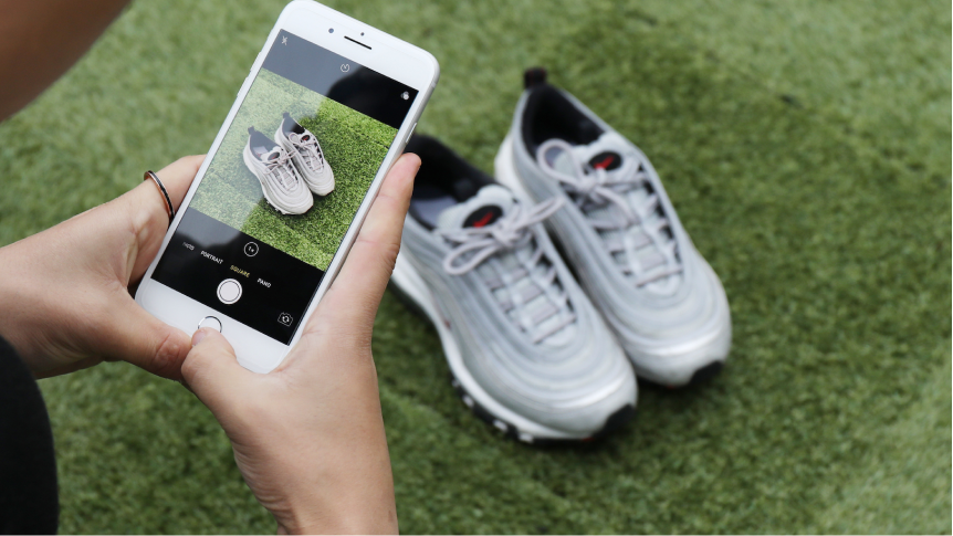 Person taking photo of shoes using mobile phone