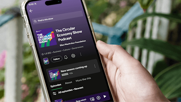 Person holding a phone that is displaying the podcast channel