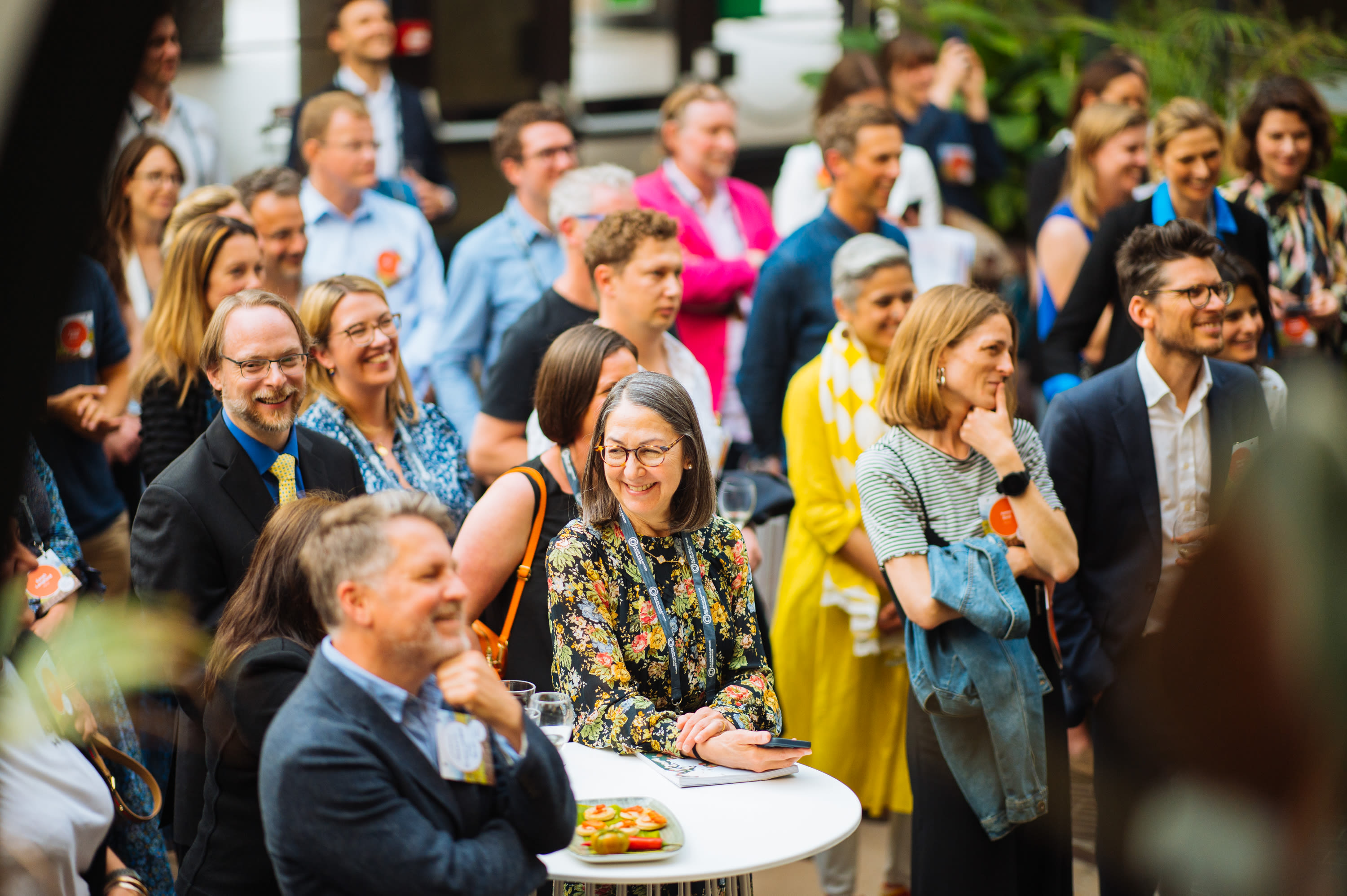 Attendees of the Big Food Redesign Challenge Launch at the Barbican smile at a guest speaker